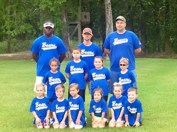 A tee ball team in blue Bears shirts posed in rows on the grass with their coaches