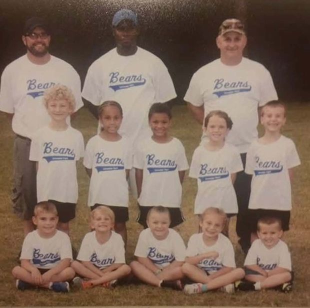A printed team photograph of children in white Bears shirts posed in three rows