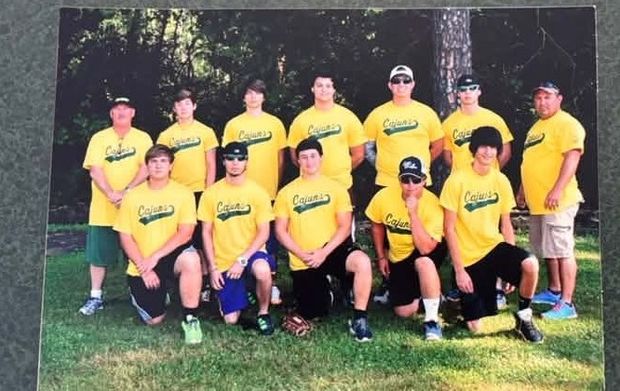 A printed team photograph of older players in yellow Cajuns shirts standing and kneeling on the grass