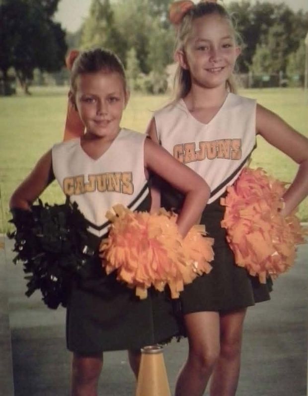 A printed photograph of two cheerleaders in Cajuns uniforms holding pompoms