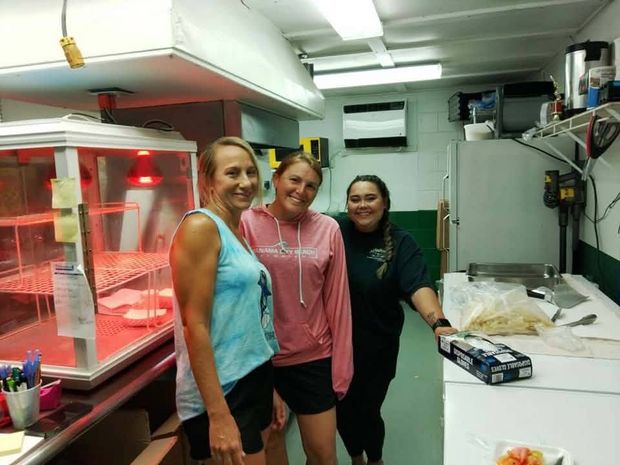 Three women working in the concession stand kitchen