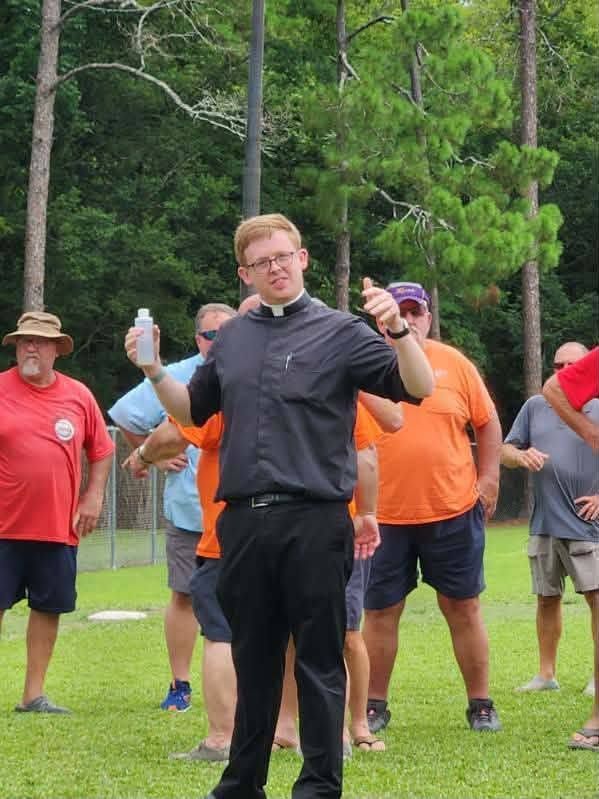 A priest standing on the field during the dedication ceremony