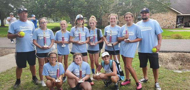 A team in light blue Fantasies shirts with coaches holding trophies