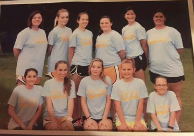 A photographed print of a team in grey shirts posed in rows