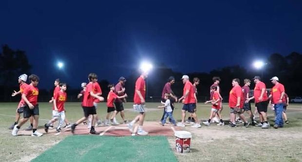 Two teams passing each other in the handshake line at night