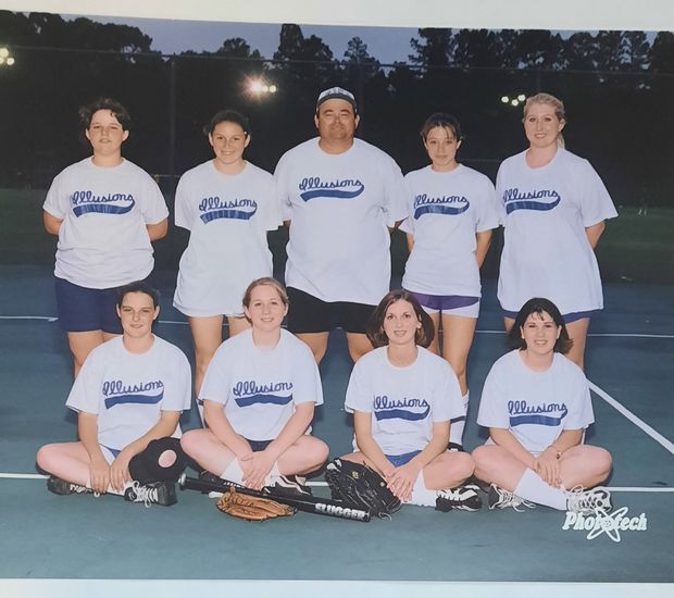 A printed team photograph of an adult team in white Illusions shirts posed on a court at night