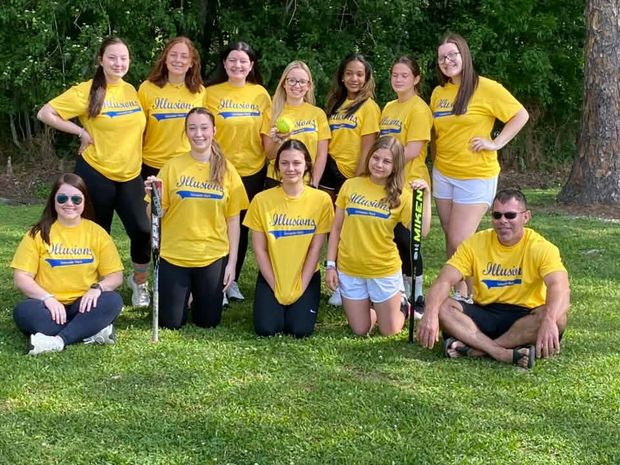 A team in yellow Illusions shirts posed in two rows on the grass