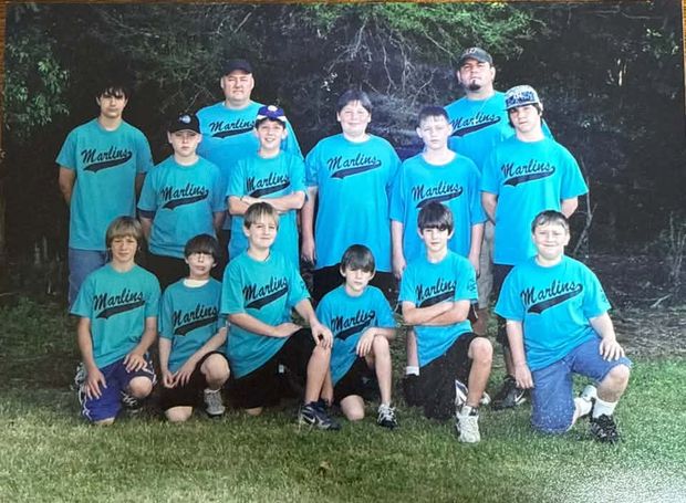A printed team photograph of players in teal Marlins shirts posed in rows