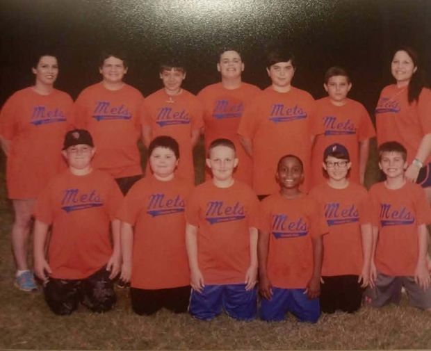 A printed team photograph of players in orange Mets shirts