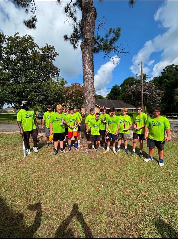 A team in neon green shirts posed together outdoors