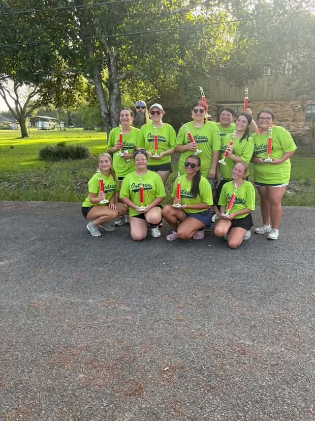 A team in neon green shirts holding red trophies