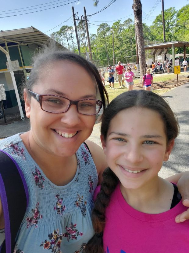 A woman and a girl smiling in a selfie at the park