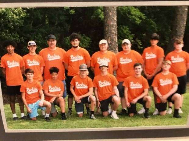 A framed printed team photograph of players in orange Rockies shirts