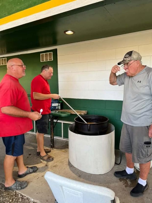 Men cooking in a large pot at the concession stand