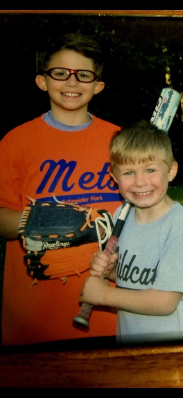 A photographed print of two boys in Mets and Wildcats shirts standing together